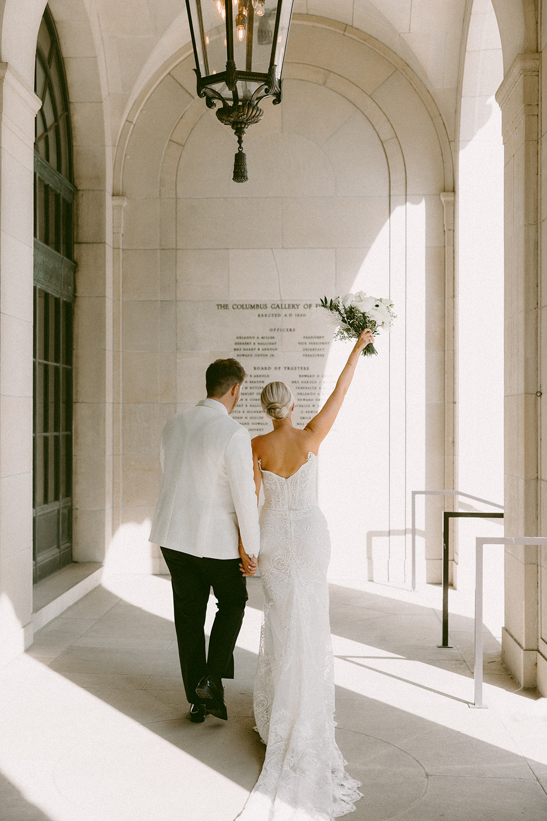 Bride and groom standing together in front of the stunning architecture at the Columbus Museum of Art, surrounded by artistic sculptures and fall foliage.